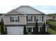 Two-story home featuring stone accents, attached two-car garage, and well-maintained landscaping at 401 Lawton Dr, Haw River, NC 27258