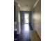 Entryway with dark floors and blue accent wall leading to open front door allowing ample natural light at 401 Lawton Dr, Haw River, NC 27258