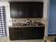 Kitchen area with brown cabinets, patterned backsplash, and dark countertops at 401 Lawton Dr, Haw River, NC 27258