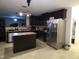 Kitchen featuring dark wood cabinets and stainless steel appliances with a view into a living room at 401 Lawton Dr, Haw River, NC 27258