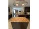 Close-up of the kitchen with stainless steel appliances, dark cabinets, and an island counter at 401 Lawton Dr, Haw River, NC 27258