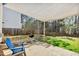 Backyard patio with a canvas awning, blue adirondack chair, grill, and lush green grass at 405 Braxman Ln, Holly Springs, NC 27540