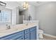 Bathroom featuring double sink vanity, stylish blue cabinets, and a well-lit mirror at 405 Braxman Ln, Holly Springs, NC 27540