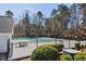 Community pool surrounded by lush landscaping and a black iron fence at 405 Braxman Ln, Holly Springs, NC 27540