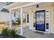 Inviting front porch featuring a stylish glass door, white pillars, and meticulous landscaping at 405 Braxman Ln, Holly Springs, NC 27540