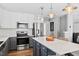 Contemporary kitchen with stainless steel appliances, white subway tile, and a large center island with barstool seating at 405 Braxman Ln, Holly Springs, NC 27540