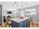 Open kitchen with a center island, stainless steel appliances, and views into the living room at 405 Braxman Ln, Holly Springs, NC 27540