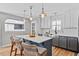 Beautiful kitchen with a gray island, white cabinets, stainless steel appliances, and modern lighting fixtures at 405 Braxman Ln, Holly Springs, NC 27540