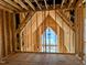 Unfinished room framed with wood beams and an A-frame structure above a large window at 405 Latimer Rd, Raleigh, NC 27609