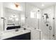 Bathroom featuring a frameless glass shower with herringbone tile and a large mirror at 4412 Beckel Rd, Willow Springs, NC 27592
