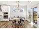 Dining area adjacent to the kitchen features a contemporary chandelier, doors to the backyard, and great natural light at 4412 Beckel Rd, Willow Springs, NC 27592