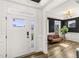 Bright foyer showcasing a white door with transom window, opening to a stylish living room with dark accent walls at 4412 Beckel Rd, Willow Springs, NC 27592