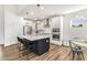 Modern kitchen with white cabinets, black island with seating, stainless steel appliances, and wood flooring at 4412 Beckel Rd, Willow Springs, NC 27592