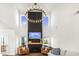 Bright living room with a striking dark accent wall, modern chandelier, and cozy fireplace at 4412 Beckel Rd, Willow Springs, NC 27592