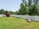 A spacious backyard featuring a swing set, sandbox, and white picket fence at 50 Dover Ridge Ct, Chapel Hill, NC 27517