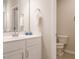 Bright bathroom featuring a vanity sink with white cabinetry and chrome fixtures, with toilet area at 50 Dover Ridge Ct, Chapel Hill, NC 27517