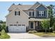 Charming two-story home with a two-car garage, covered porch, and attractive landscaping on a sunny day at 50 Dover Ridge Ct, Chapel Hill, NC 27517