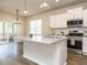 Bright kitchen featuring a center island with sink, granite countertops, stainless steel appliances and white cabinets at 50 Dover Ridge Ct, Chapel Hill, NC 27517