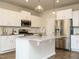 Modern kitchen featuring a center island with sink, granite countertops, stainless steel appliances, and white cabinets at 50 Dover Ridge Ct, Chapel Hill, NC 27517
