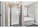 Bathroom with glass shower, large tub, tile floors, and modern fixtures at 500 Wakefield Dr, Princeton, NC 27569