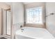 Bright bathroom featuring a tub with a decorative window and a separate glass-enclosed shower at 500 Wakefield Dr, Princeton, NC 27569