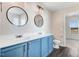 Bathroom with dual sinks, blue vanity, modern mirrors, and wood floors at 500 Wakefield Dr, Princeton, NC 27569