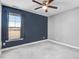 This carpeted bedroom is well lit by a window with blue walls and a ceiling fan at 500 Wakefield Dr, Princeton, NC 27569