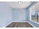 Cozy bedroom with wood-look flooring, soft blue walls, and natural light from a window at 500 Wakefield Dr, Princeton, NC 27569