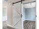 Flex space featuring a sliding barn door, wood-look flooring, and soft blue walls at 500 Wakefield Dr, Princeton, NC 27569