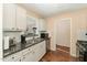 Galley kitchen featuring stainless steel appliances, granite countertops, and dark wood flooring at 5816 Pointer Dr # 102, Raleigh, NC 27609