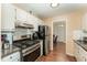 Kitchen with stainless appliances, granite counters, tile backsplash, and dark wood flooring at 5816 Pointer Dr # 102, Raleigh, NC 27609