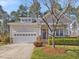 Charming single Gathering home featuring manicured lawn, stone accents, covered porch, and attached two-car garage at 5910 Lacebark Ln, Durham, NC 27713