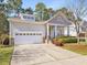 Charming single Gathering home featuring manicured lawn, stone accents, covered porch, and attached two-car garage at 5910 Lacebark Ln, Durham, NC 27713