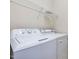 Laundry room with GE washer and dryer with metal shelving above at 5910 Lacebark Ln, Durham, NC 27713