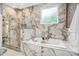Luxurious marble bathroom with a soaking tub, glass shower, and natural light at 601 Lee St, Durham, NC 27701