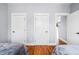 Cozy bedroom with hardwood floors, neutral walls, and direct access to other rooms in the home at 601 Lee St, Durham, NC 27701