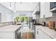 Modern white kitchen with stainless steel appliances, mosaic backsplash, and pendant lighting at 601 Lee St, Durham, NC 27701