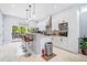 Bright open kitchen with modern white cabinets, bar seating, and stainless steel appliances at 601 Lee St, Durham, NC 27701