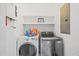 Functional laundry area with modern washer, dryer, shelving, and utility sink at 601 Lee St, Durham, NC 27701