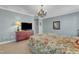 Bedroom features floral bedding, a dresser, and a mirror with chandelier lighting at 637 Copper Beech Ln, Wake Forest, NC 27587