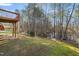 A sloped backyard featuring mature trees, a lake, and a glimpse of the deck at 6715 Winding Arch Dr, Durham, NC 27713