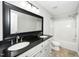 Modern bathroom boasts a double sink vanity with black countertop and shower-tub combination at 6715 Winding Arch Dr, Durham, NC 27713