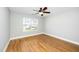 Inviting bedroom features hardwood floors, a ceiling fan, and a large window at 6715 Winding Arch Dr, Durham, NC 27713