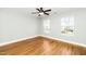 Cozy bedroom features hardwood floors, a ceiling fan, and two large windows at 6715 Winding Arch Dr, Durham, NC 27713