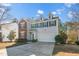 Two-story home featuring a brick facade, neutral siding and a two-car garage on a sunny day at 6715 Winding Arch Dr, Durham, NC 27713