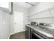 Functional laundry room with modern washer and dryer and convenient shelving and sink at 6715 Winding Arch Dr, Durham, NC 27713
