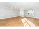 Open living room featuring hardwood floors, neutral paint, and a modern chandelier at 6715 Winding Arch Dr, Durham, NC 27713