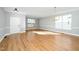 Spacious living room featuring hardwood floors, neutral paint, and large windows at 6715 Winding Arch Dr, Durham, NC 27713