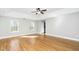 Spacious main bedroom featuring a ceiling fan, tray ceiling, hardwood floors and windows at 6715 Winding Arch Dr, Durham, NC 27713