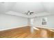 Spacious main bedroom with a ceiling fan, tray ceiling, hardwood floors and windows at 6715 Winding Arch Dr, Durham, NC 27713